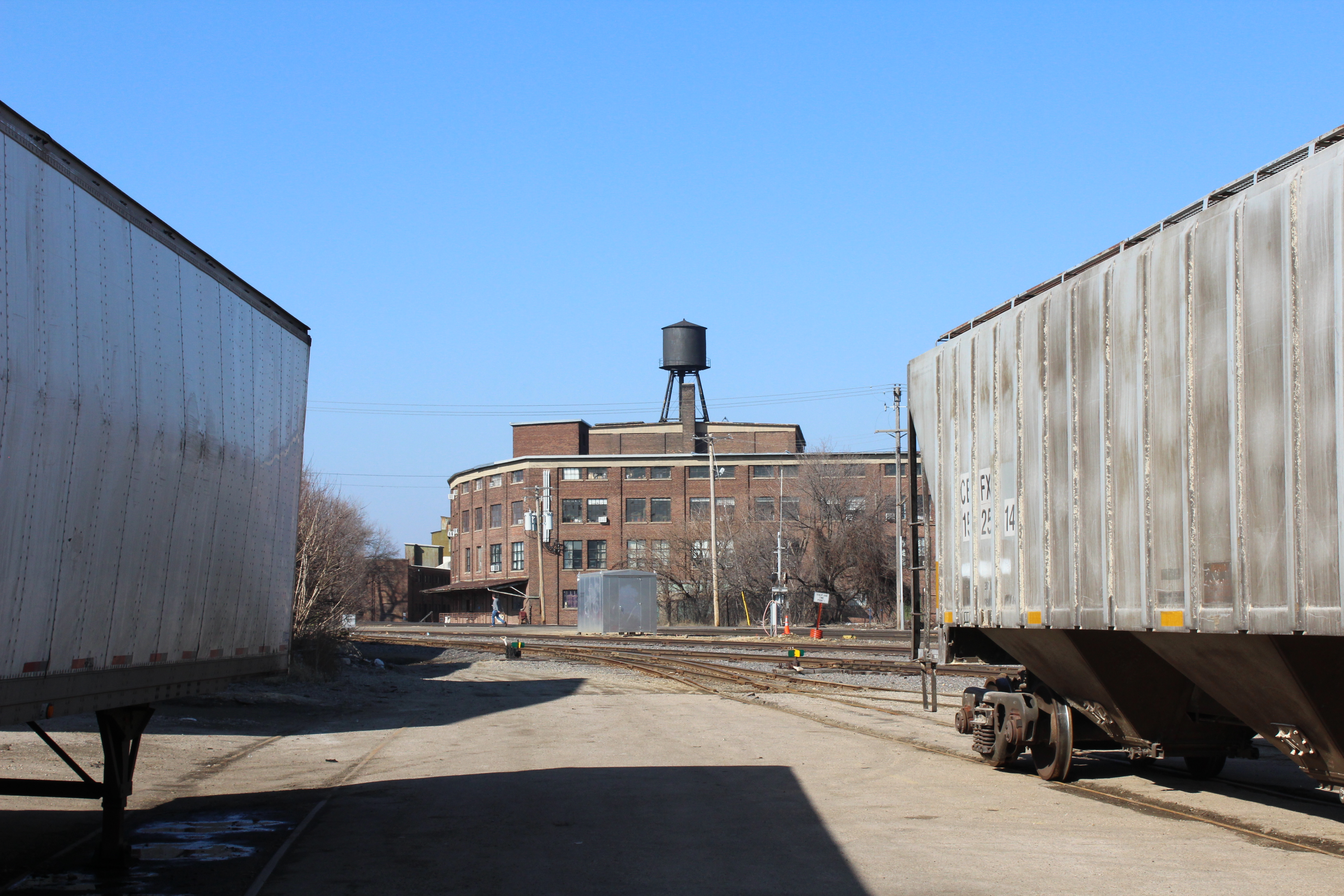 Freight trains in foreground and older brick building in background