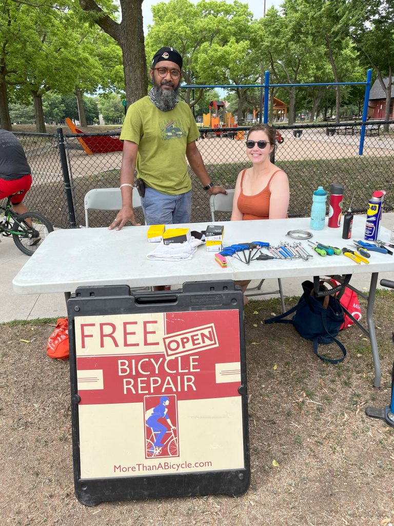 Two people hosting the Recovery Bike shop table at the LPNA Bike Rodeo